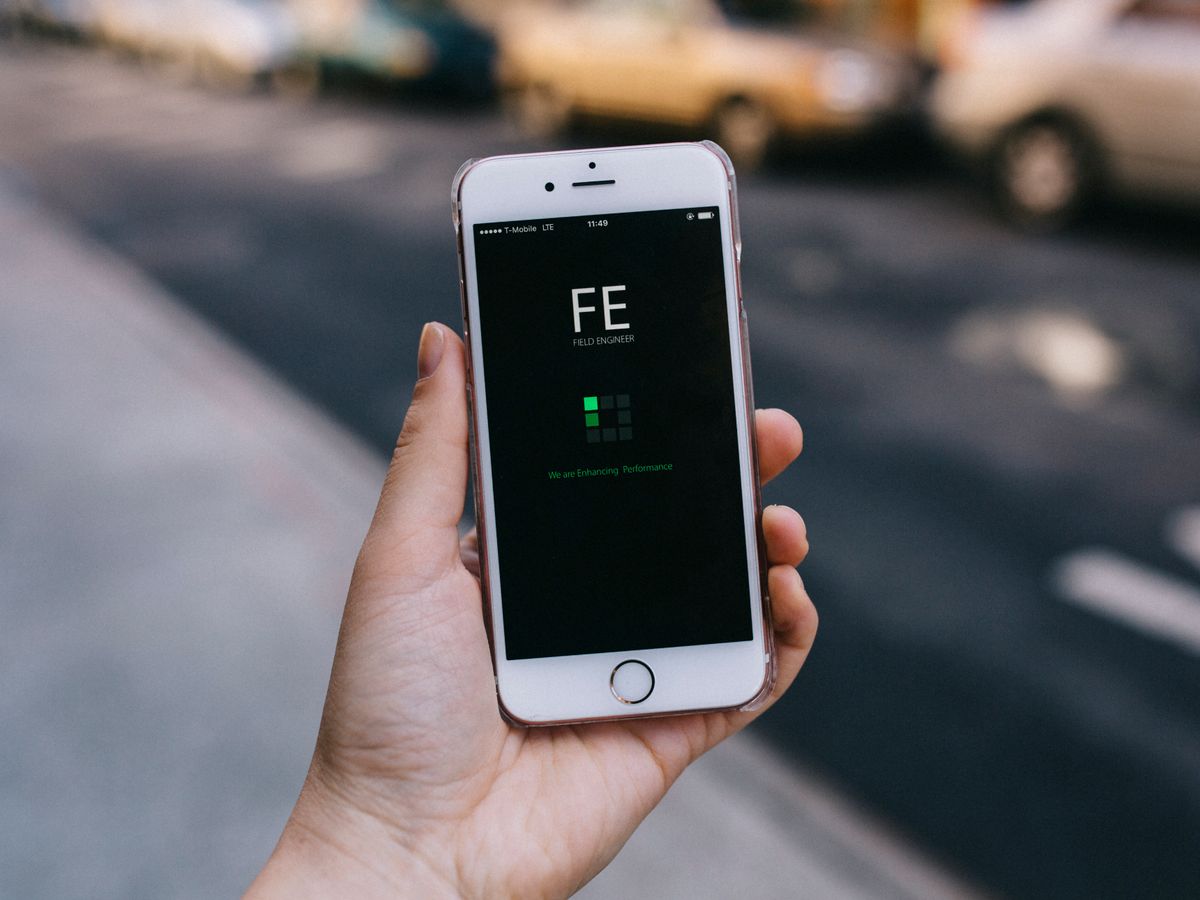 Smartphone com um aplicativo na tela segurado por uma pessoa.